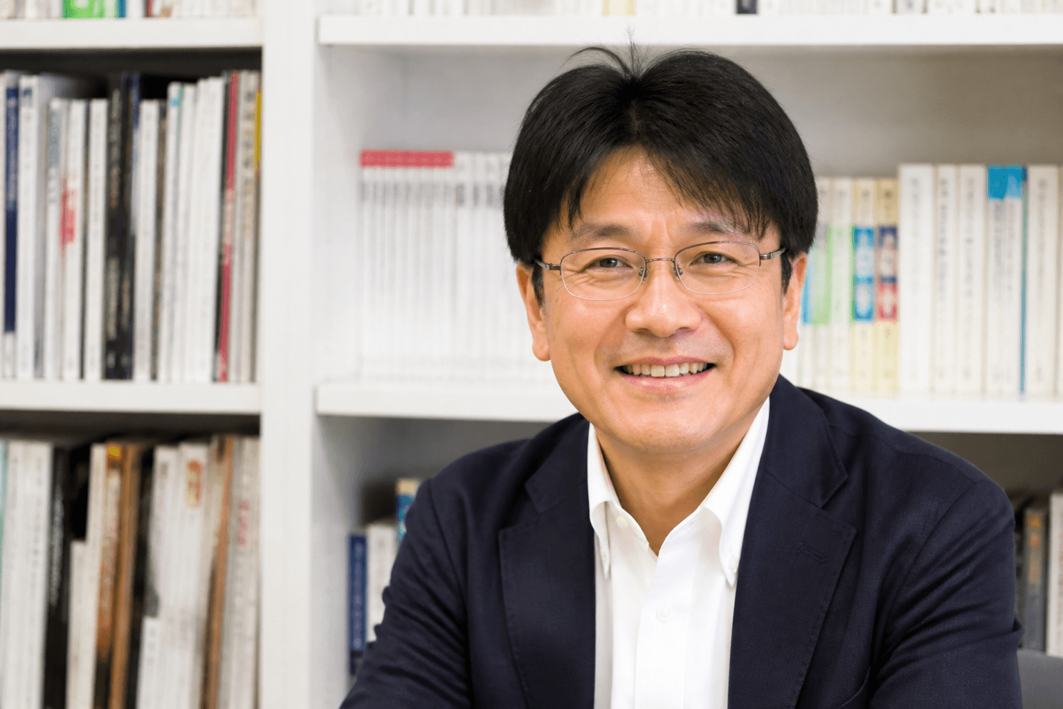 光出版の編集長・酒井氏の顔写真。信頼感と温かみが伝わる、笑顔の写真が望ましい。]