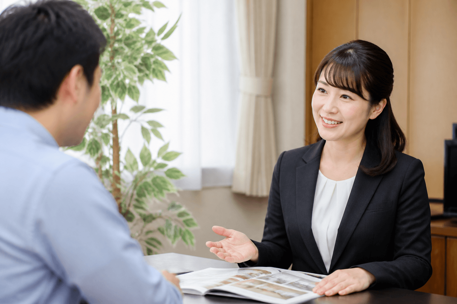 編集者とお客様が和やかな雰囲気の応接室で、笑顔で話している無料相談の様子の写真]