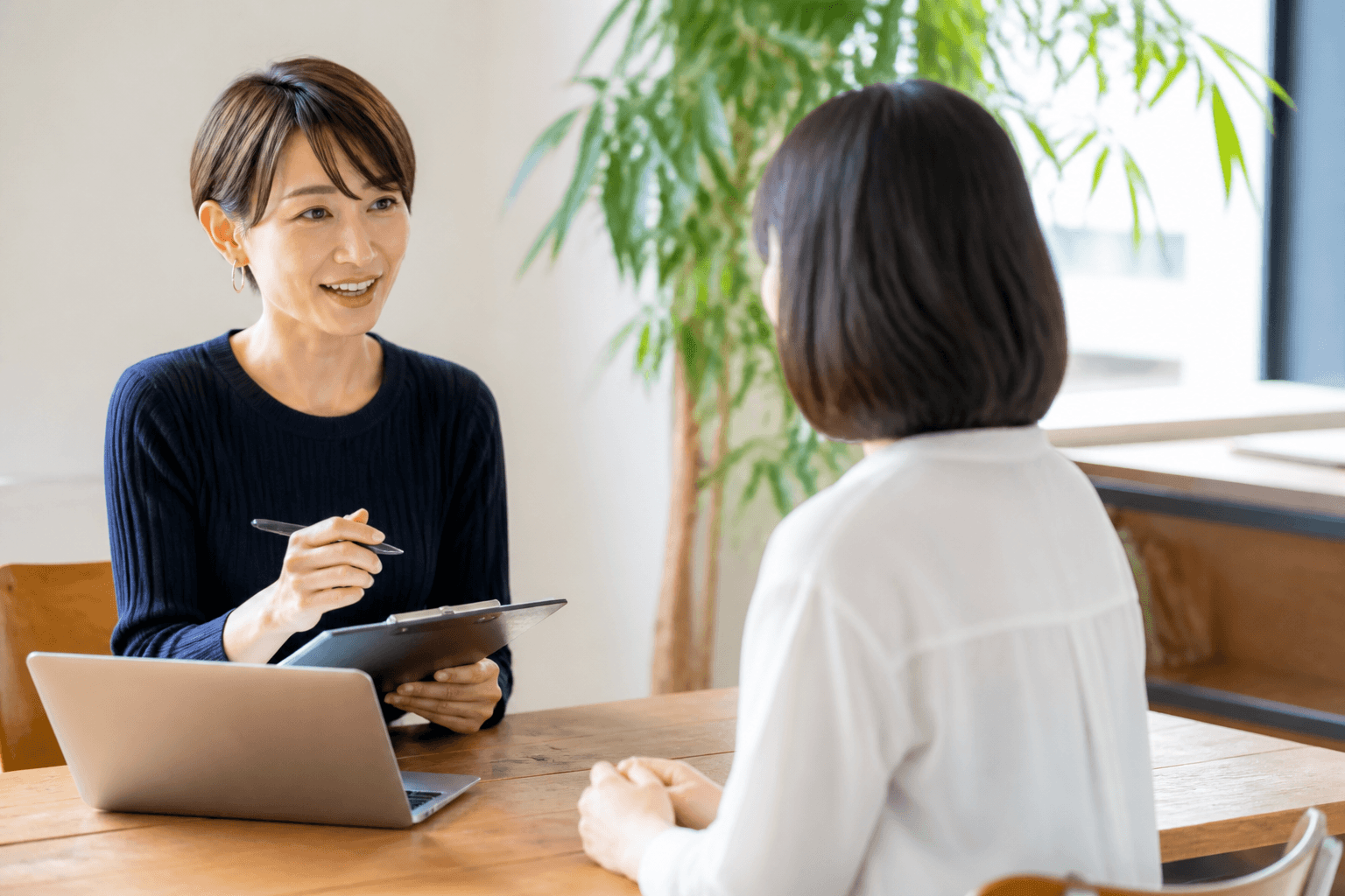 編集者とお客様が和やかな雰囲気で対話（取材）している様子の写真]