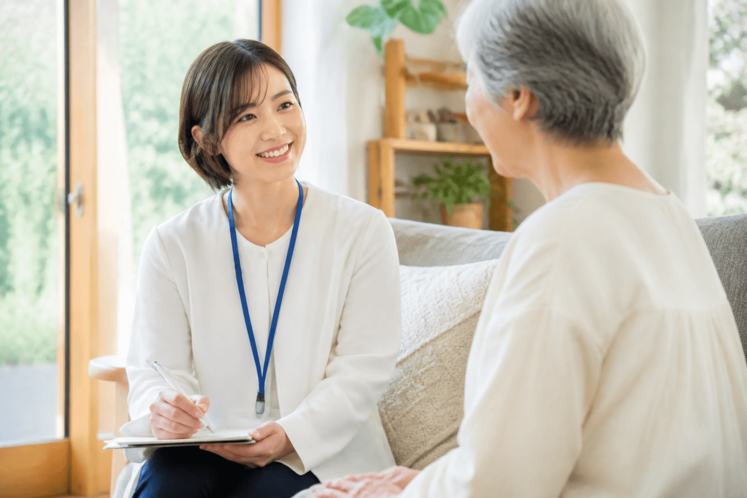 ライターがお客様（シニア世代）のお話を笑顔で聞いているインタビュー風景の写真。和やかな雰囲気で「話すだけ」というコンセプトを視覚的に伝える。]