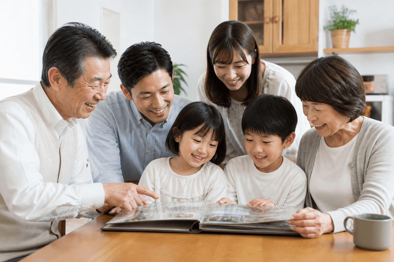 祖父母や両親、子どもたちが一緒に昔のアルバムを囲んで、楽しそうに話している様子の写真]